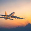 Passanger airplane flying above clouds in evening.