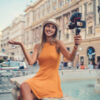 Young woman on a summer vacation vlogging from the city