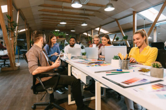 Young designers working with project, discussing new order development in modern office