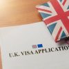 Visa application on desktop with passport and union jack wallet