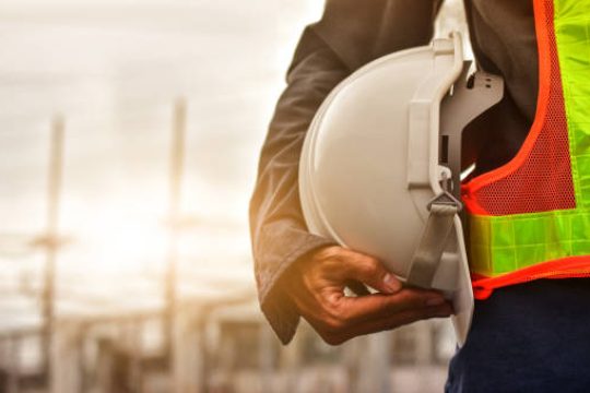 Technician holding white hat safety hard hat sunlight background