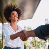 Businessman and woman shake hands like hello in office closeup.